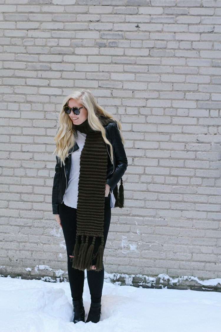 A faux leather jacket, booties, and an oversized scarf for a winter date night outfit