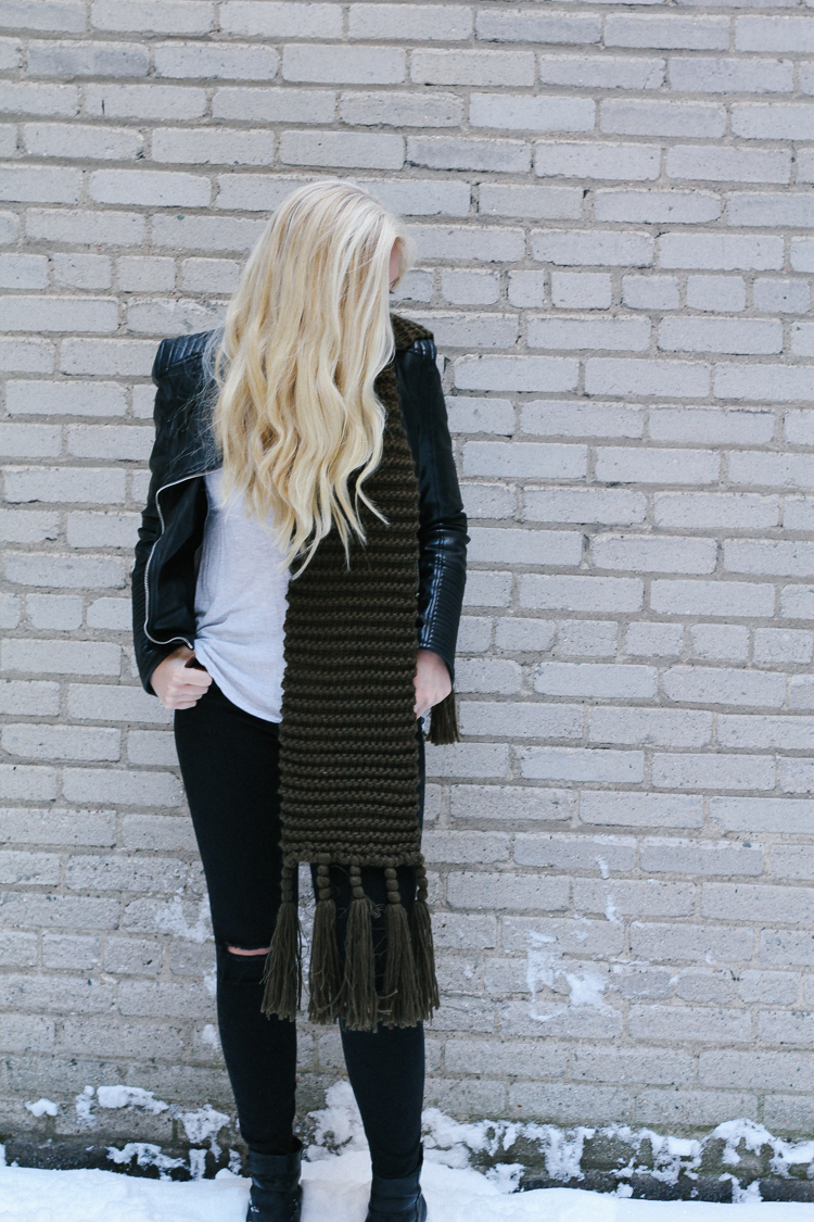 A faux leather jacket, booties, and an oversized scarf for a winter date night outfit