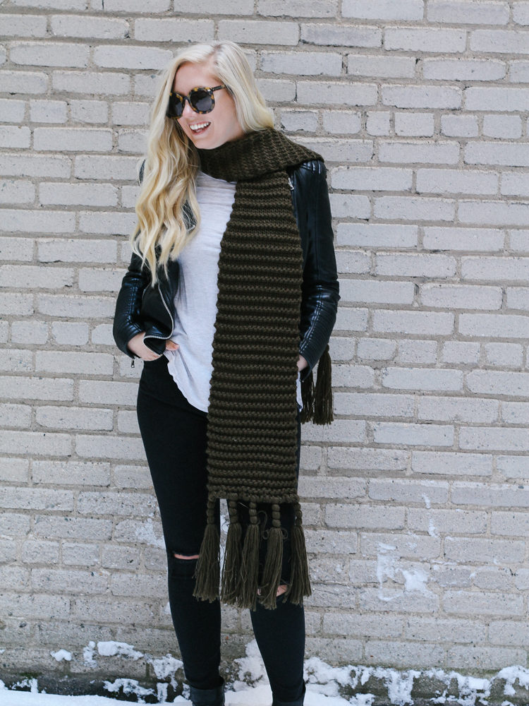 A faux leather jacket, booties, and an oversized scarf for a winter date night outfit