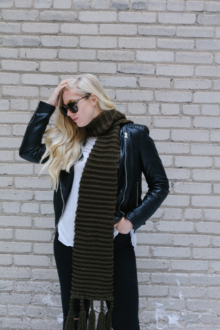 A faux leather jacket, booties, and an oversized scarf for a winter date night outfit