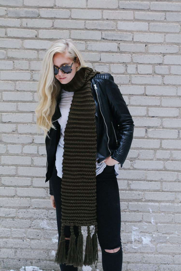 A faux leather jacket, booties, and an oversized scarf for a winter date night outfit