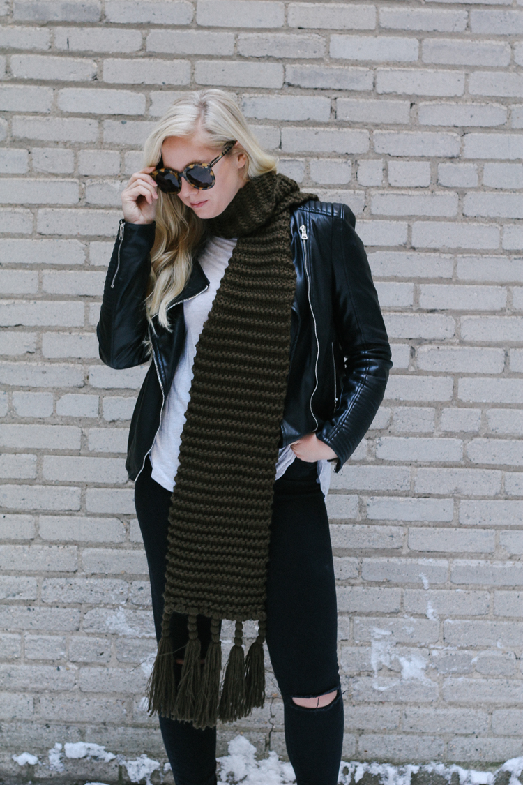 A faux leather jacket, booties, and an oversized scarf for a winter date night outfit