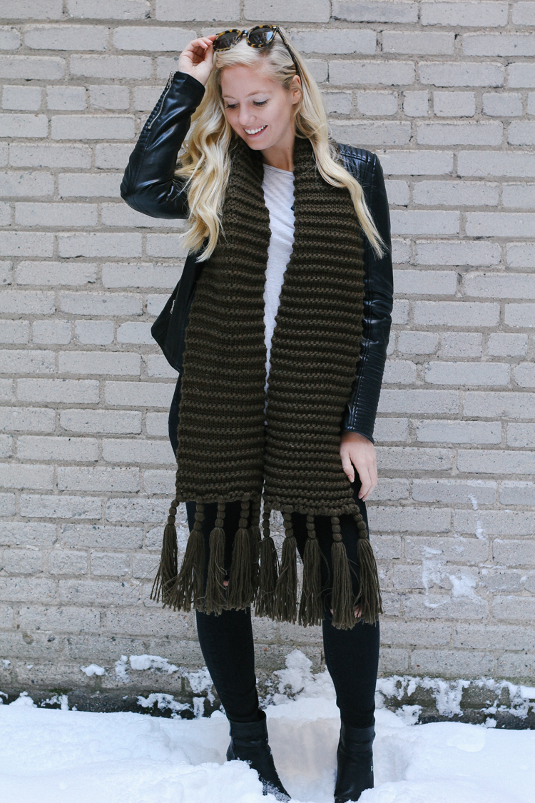 A faux leather jacket, booties, and an oversized scarf for a winter date night outfit