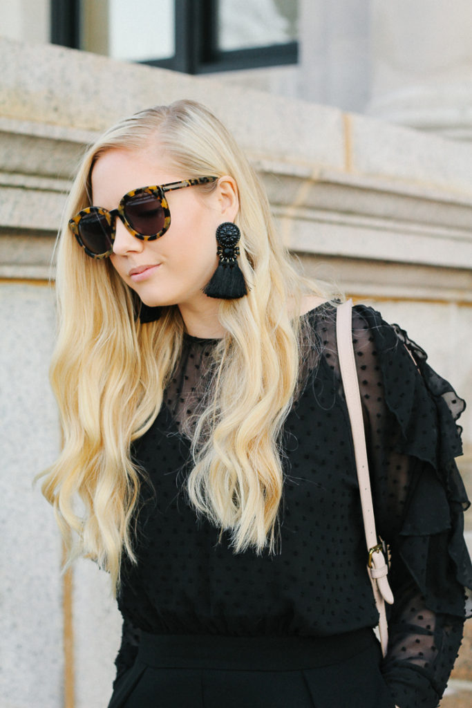 black jumpsuit, black statement earrings, big sunglasses, 