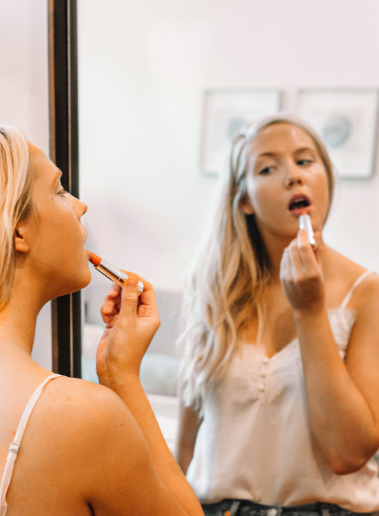 Why I'm careful about buying beauty products on Amazon | beauty products on Amazon | what to watch for when buying beauty products on Amazon | blonde woman in pink tank top putting lipstick on in mirror |